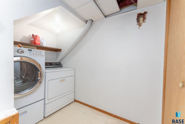 laundry area with light floors, laundry area, and washing machine and dryer