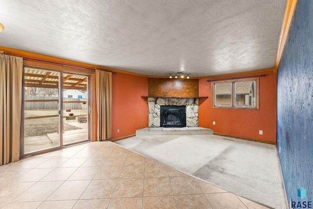 unfurnished living room with track lighting, a fireplace, baseboards, a textured ceiling, and tile patterned floors