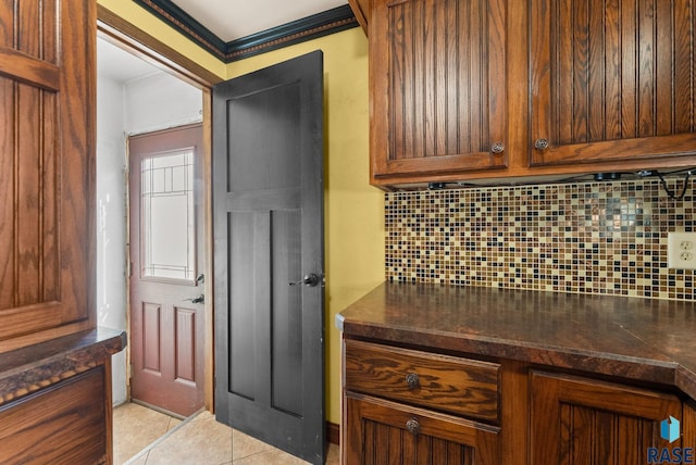 interior space with light tile patterned flooring, dark countertops, and decorative backsplash