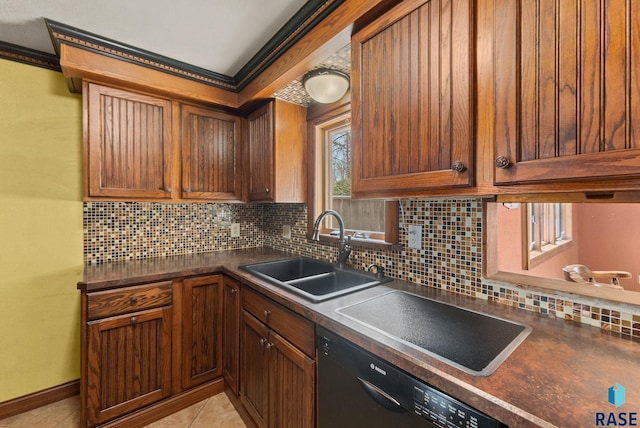 kitchen with black dishwasher, dark countertops, a sink, and tasteful backsplash