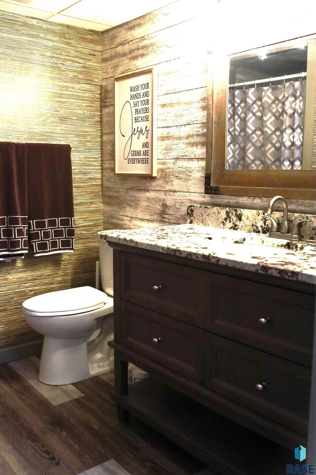 1408 N Tahoe Trl, Sioux Falls, SD 57110 - full bathroom featuring a sink, double vanity, toilet, curtained shower, and wood finished floors