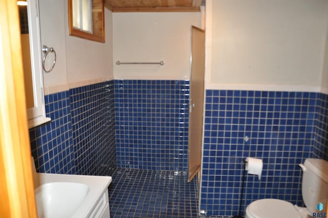2911 S Norton Ave, Sioux Falls, SD 57105 - full bathroom featuring tile walls, a wainscoted wall, and toilet