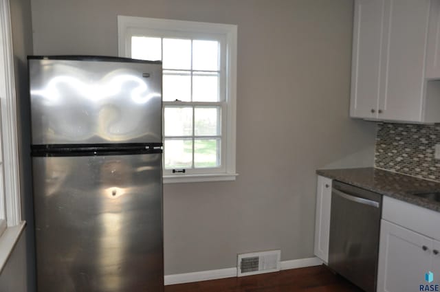 2911 S Norton Ave, Sioux Falls, SD 57105 - kitchen with stainless steel appliances, baseboards, white cabinetry, decorative backsplash, and visible vents