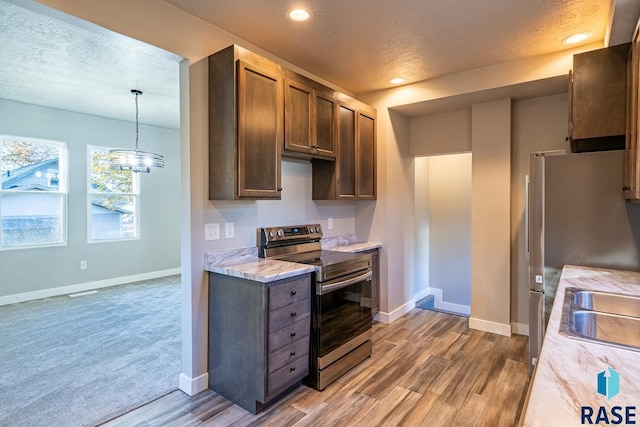 kitchen featuring light countertops, baseboards, stainless steel appliances, and a textured ceiling