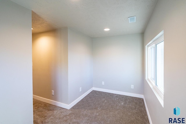 unfurnished room with carpet floors, a textured ceiling, baseboards, and recessed lighting