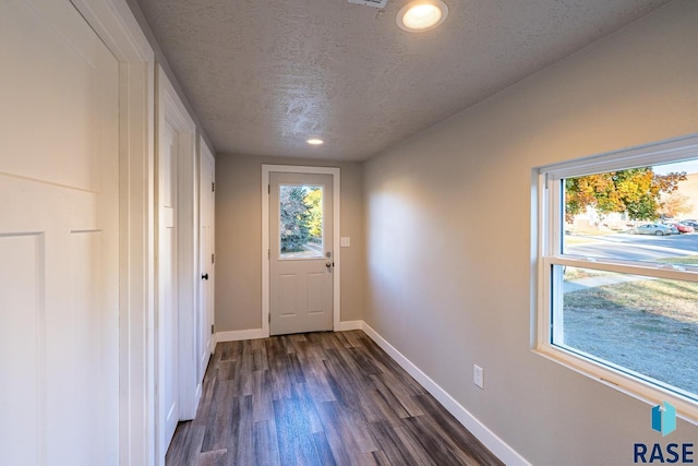 doorway to outside featuring baseboards, recessed lighting, a textured ceiling, and dark wood-style floors