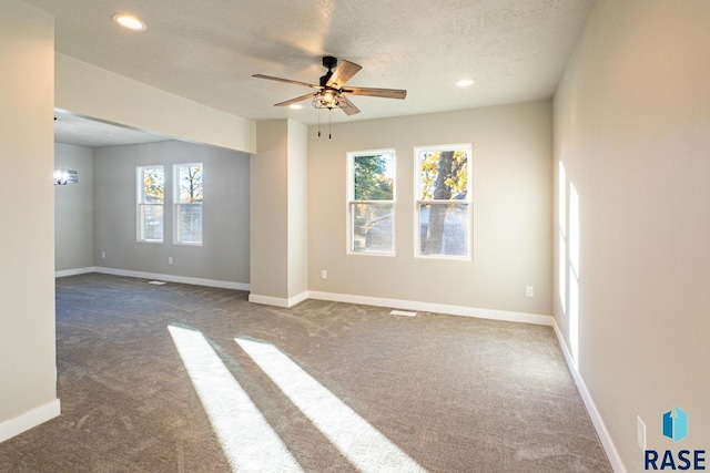 spare room with carpet flooring, a ceiling fan, baseboards, and a wealth of natural light