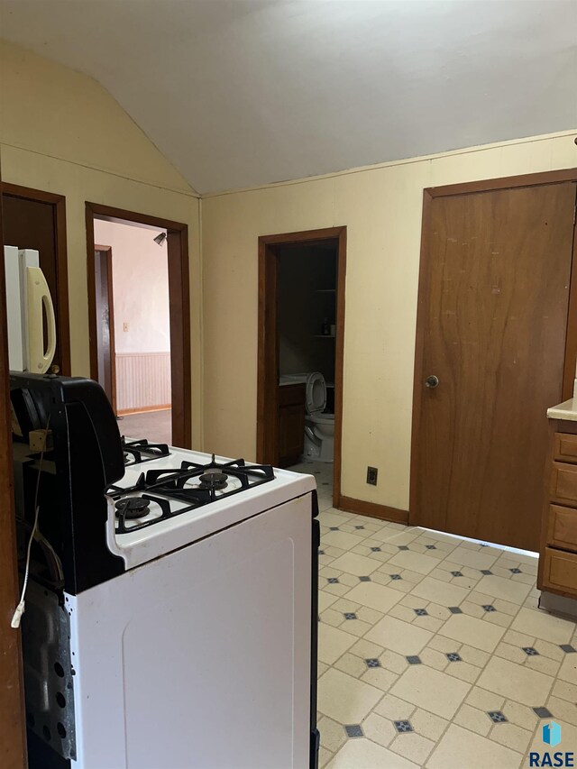 interior space featuring range with gas stovetop, lofted ceiling, and white microwave