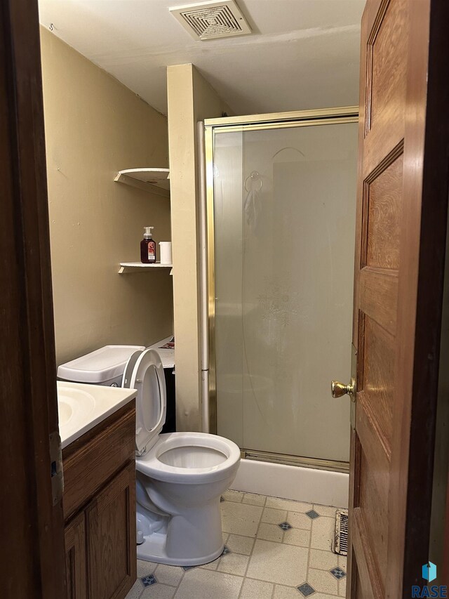 full bath with visible vents, a shower stall, vanity, tile patterned floors, and toilet