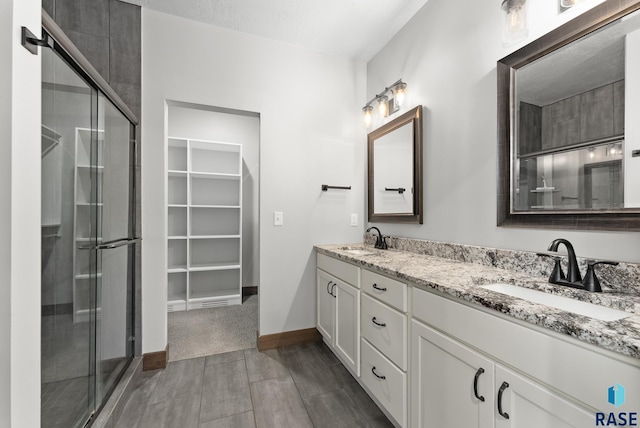 bathroom featuring a sink, wood finished floors, and a stall shower