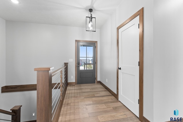 doorway with light wood-type flooring, recessed lighting, and baseboards