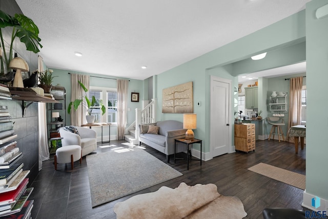 living room with recessed lighting, baseboards, dark wood-style floors, and stairway