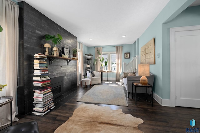 living area featuring wood finished floors, a fireplace, baseboards, stairway, and recessed lighting