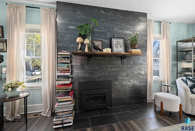 living area with plenty of natural light, a fireplace, and wood finished floors