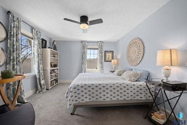 carpeted bedroom with baseboards, a textured ceiling, and ceiling fan