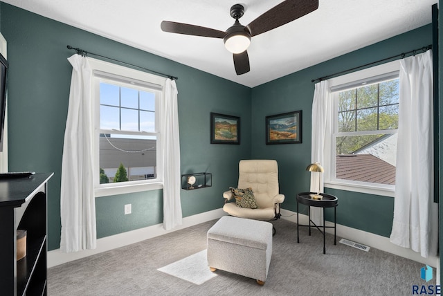 sitting room with visible vents, a ceiling fan, baseboards, and carpet floors
