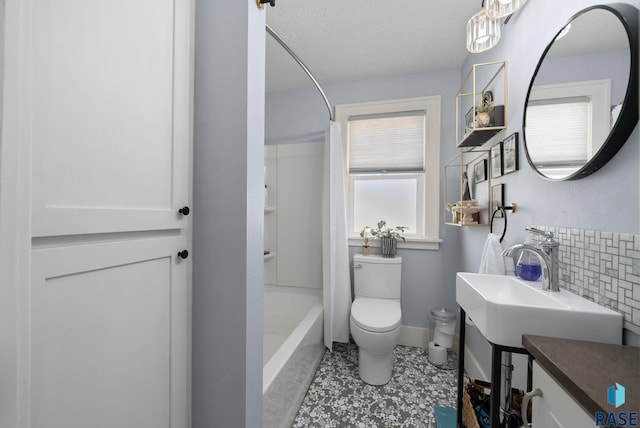 full bathroom featuring toilet, baseboards, tasteful backsplash, a sink, and shower / tub combo