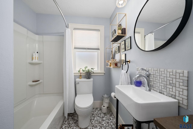 full bath with a textured ceiling, shower / tub combo, vanity, baseboards, and toilet