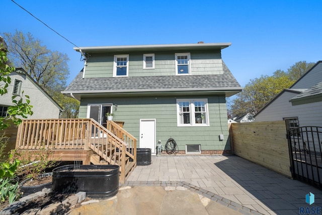 back of house with a patio, fence, a shingled roof, and a gate