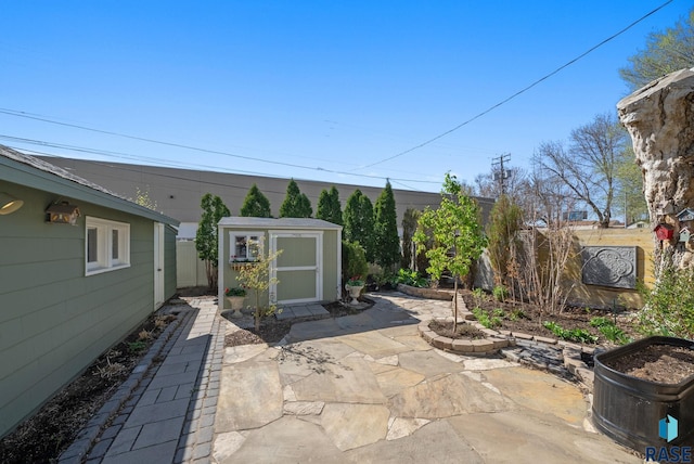 view of patio / terrace featuring fence, an outbuilding, and a shed