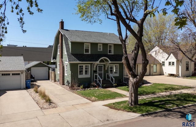 dutch colonial with a gambrel roof, roof with shingles, driveway, and a chimney