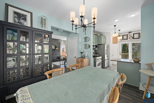 dining room with baseboards, wood finished floors, and a notable chandelier