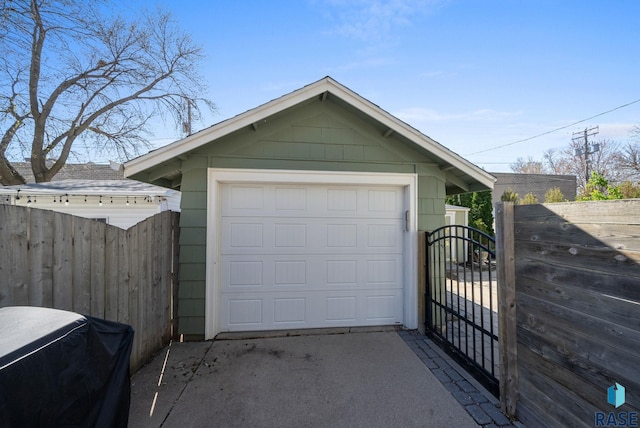 detached garage with a gate and fence