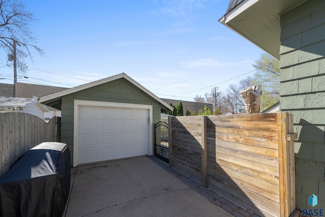view of property exterior featuring a garage, a gate, fence, and driveway