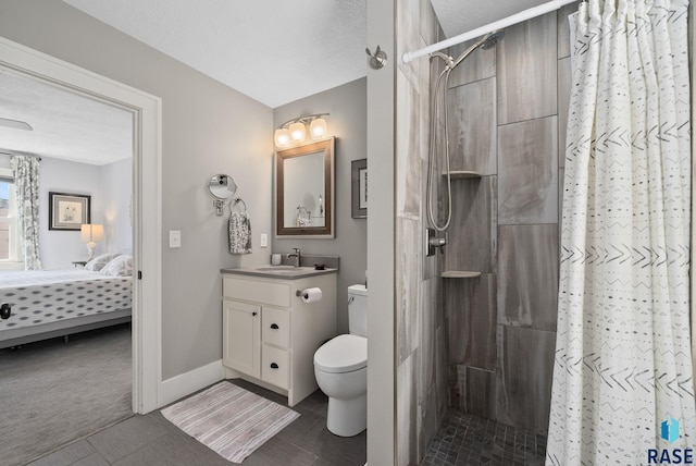bathroom featuring connected bathroom, a tile shower, tile patterned flooring, vanity, and toilet