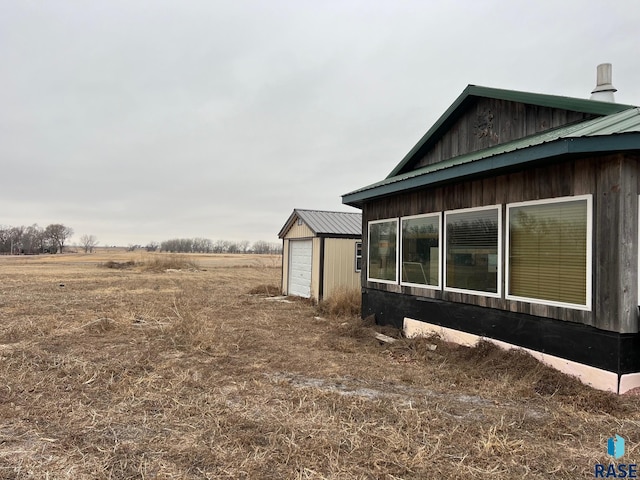 view of property exterior featuring an outbuilding and metal roof