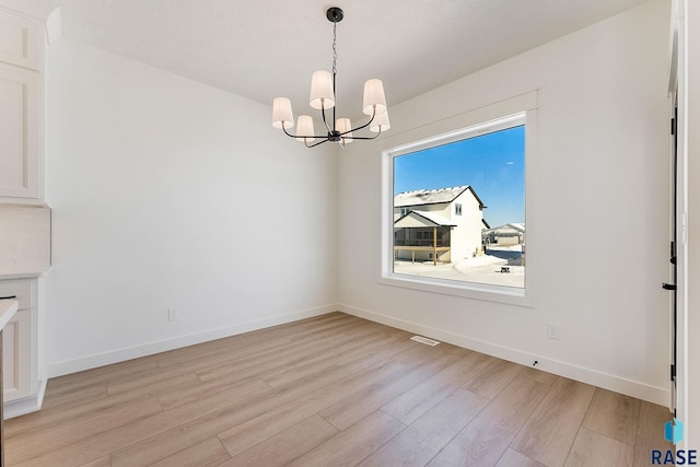 2700 N Vermillion Cir, Tea, SD 57064 - unfurnished dining area featuring baseboards, a chandelier, light wood-style flooring, and visible vents
