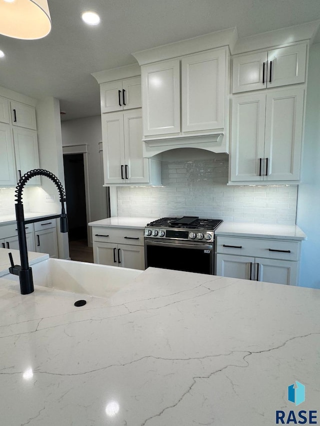 2700 N Vermillion Cir, Tea, SD 57064 - kitchen featuring light stone countertops, stainless steel range with gas cooktop, recessed lighting, white cabinets, and backsplash