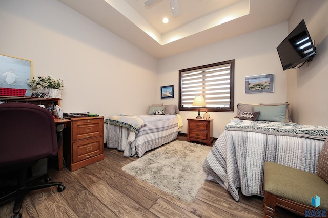 bedroom featuring recessed lighting, dark wood finished floors, ceiling fan, and a tray ceiling