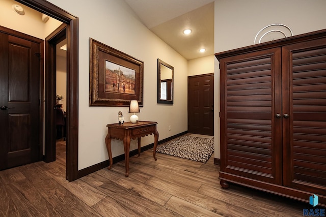 hallway with recessed lighting, baseboards, dark wood finished floors, and lofted ceiling