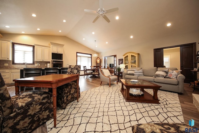 living area with light wood-style floors, high vaulted ceiling, a ceiling fan, and recessed lighting
