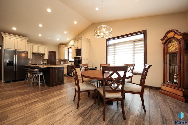 dining area featuring an inviting chandelier, recessed lighting, dark wood finished floors, and vaulted ceiling