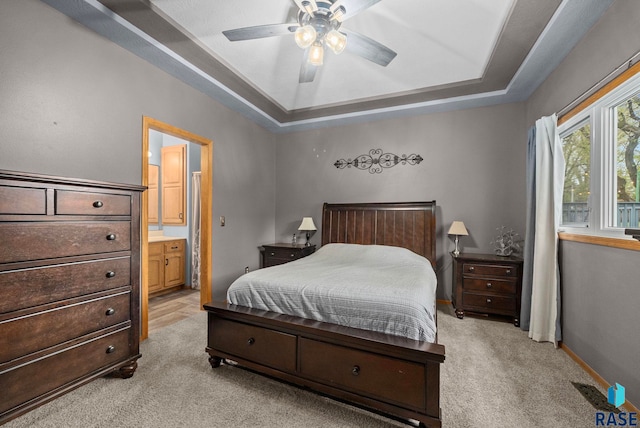 5215 E Belmont St, Sioux Falls, SD 57110 - bedroom with ceiling fan, light colored carpet, baseboards, ensuite bathroom, and a tray ceiling