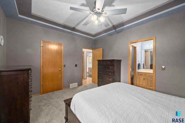 5215 E Belmont St, Sioux Falls, SD 57110 - carpeted bedroom with connected bathroom, ceiling fan, visible vents, and a raised ceiling