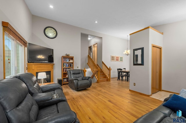 5215 E Belmont St, Sioux Falls, SD 57110 - living area featuring a multi sided fireplace, light wood-type flooring, stairway, a notable chandelier, and recessed lighting