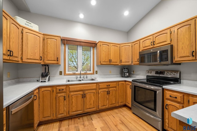 5215 E Belmont St, Sioux Falls, SD 57110 - kitchen featuring appliances with stainless steel finishes, brown cabinets, a sink, light countertops, and light wood finished floors