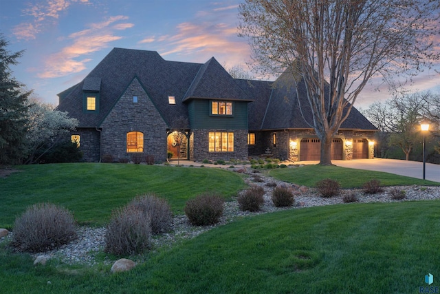 1705 N Deer Hollow Cir, Sioux Falls, SD 57110 - french country style house featuring an attached garage, a lawn, stone siding, and concrete driveway