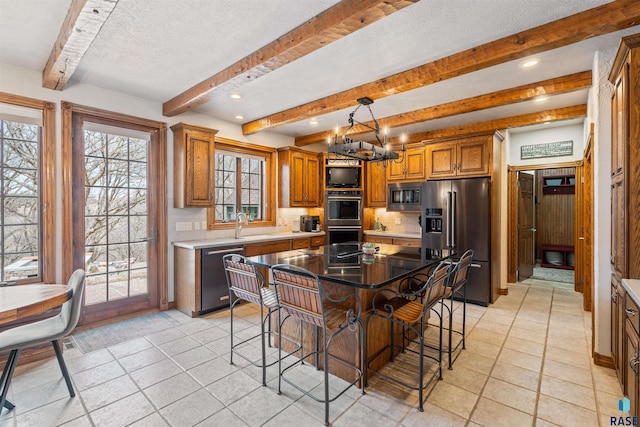 1705 N Deer Hollow Cir, Sioux Falls, SD 57110 - kitchen with light tile patterned floors, beamed ceiling, stainless steel appliances, and brown cabinets