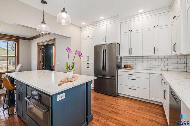 kitchen with white cabinets, appliances with stainless steel finishes, light wood-style floors, recessed lighting, and decorative backsplash