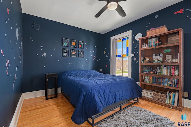 bedroom with baseboards, a ceiling fan, and wood finished floors