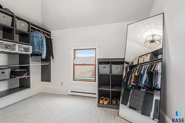 walk in closet featuring a baseboard radiator, carpet flooring, and lofted ceiling