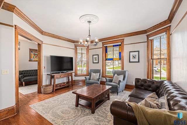 living room with ornamental molding, a chandelier, and a healthy amount of sunlight
