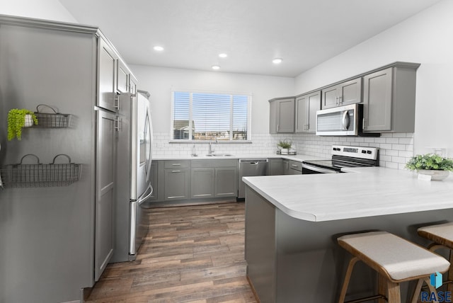 5400 S Whisper Cove Trl, Sioux Falls, SD 57108 - kitchen with stainless steel appliances, a sink, gray cabinets, and a peninsula