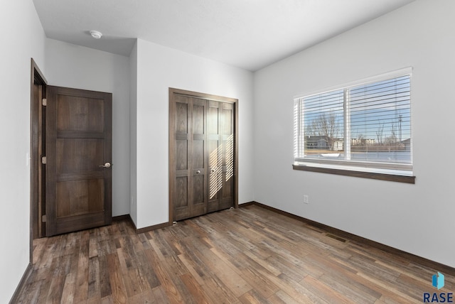 5400 S Whisper Cove Trl, Sioux Falls, SD 57108 - unfurnished bedroom featuring a closet, baseboards, and wood finished floors