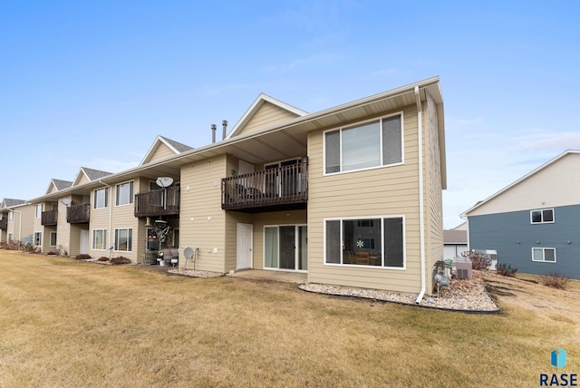 back of property featuring a lawn, central air condition unit, and a balcony