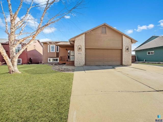 view of front of home featuring brick siding, driveway, a front yard, and a garage